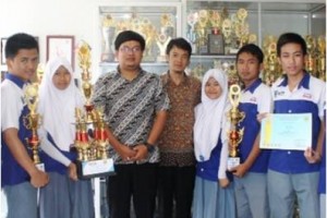 Kepala Sekolah SMK Pertiwi berfoto bersama dengan siswanya yang berprestasi.